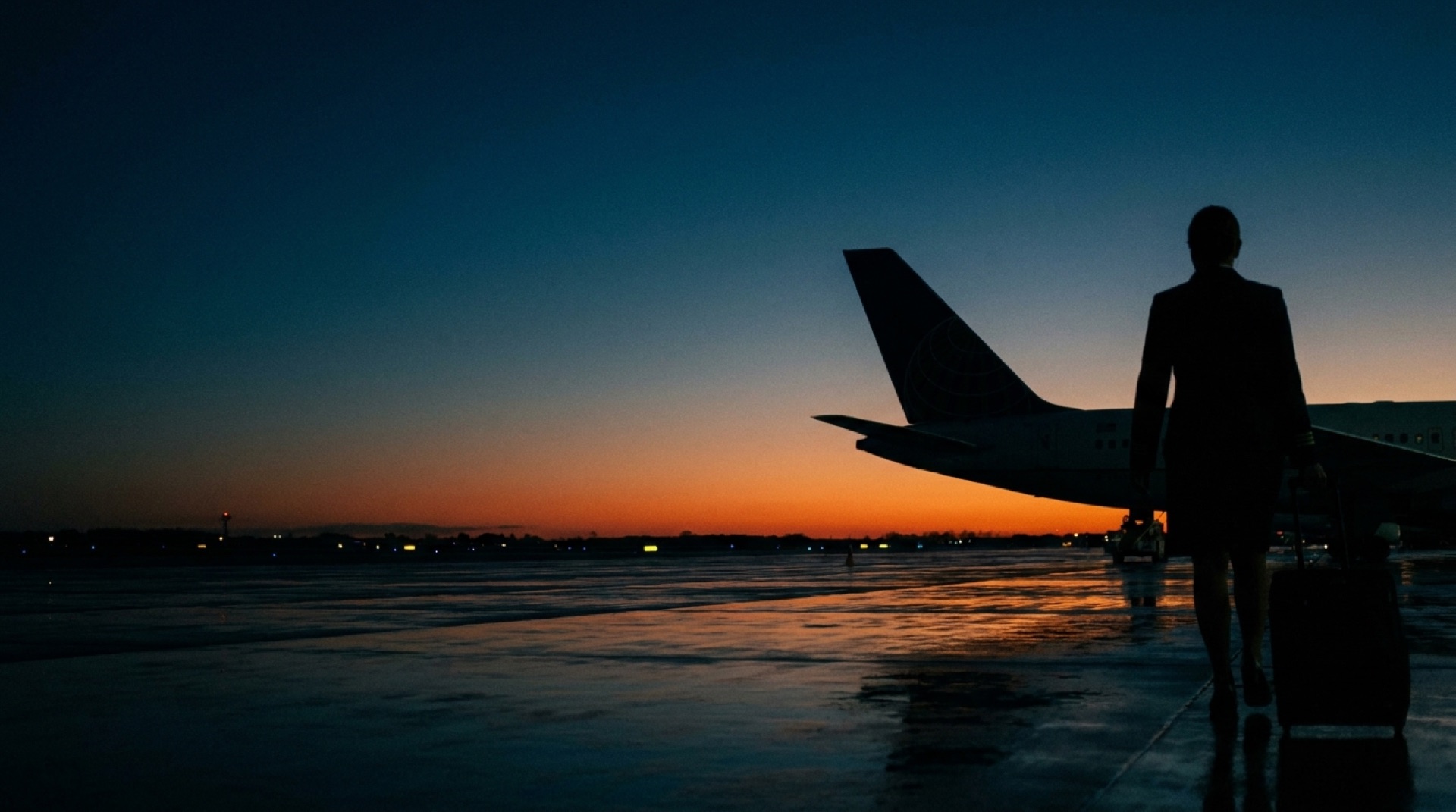 Airline crew member walking to the aircraft at dawn
